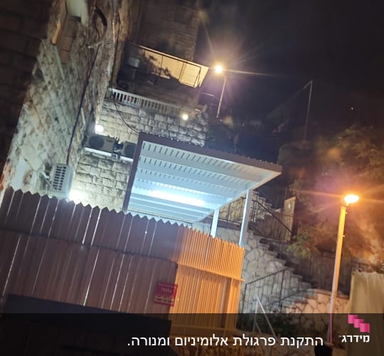 פרגולת אלומיניום לבנה מותקנת בחצר בית בשעות הלילה